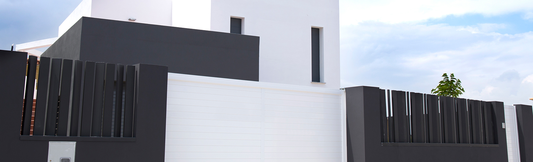 Portes d'accés a un habitatge unifamiliar realitzades en alumini lacat en blanc