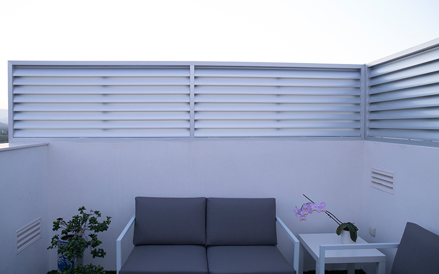 Celosía divisoria en terraza ático realizada en aluminio anodizado con lama curva